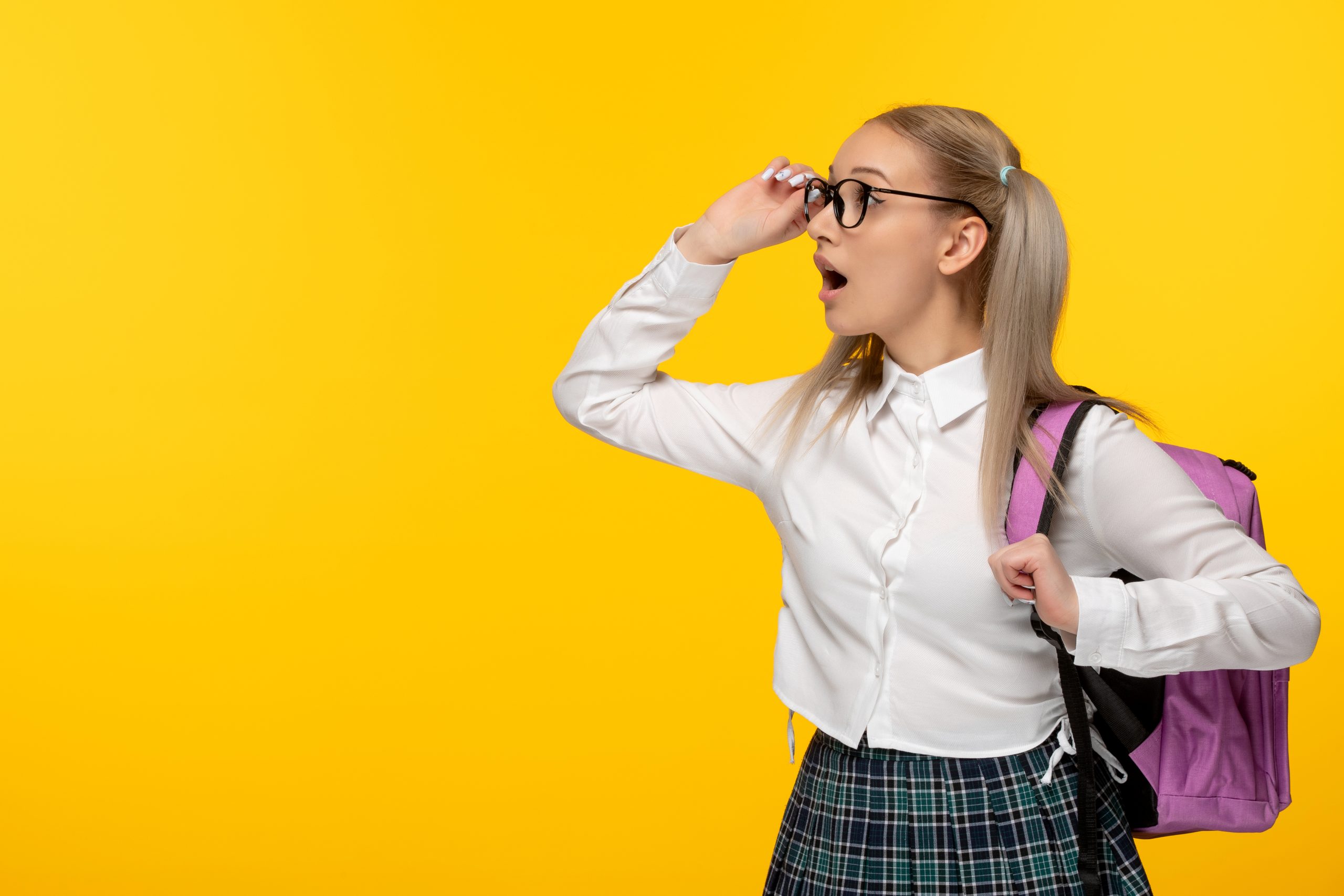 world book day cute schoolgirl looking far glasses with pink backpack